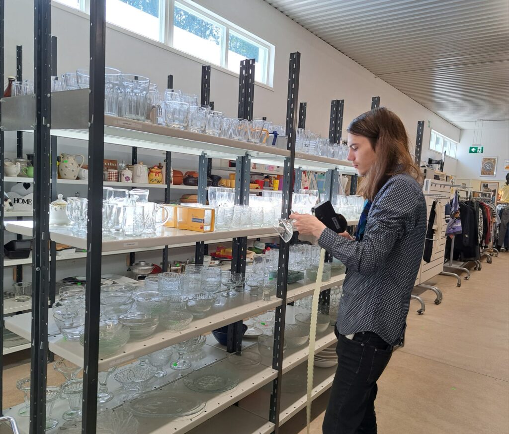 Kuva lasiastioiden hinnoittelusta kierrätysmyymälässä.